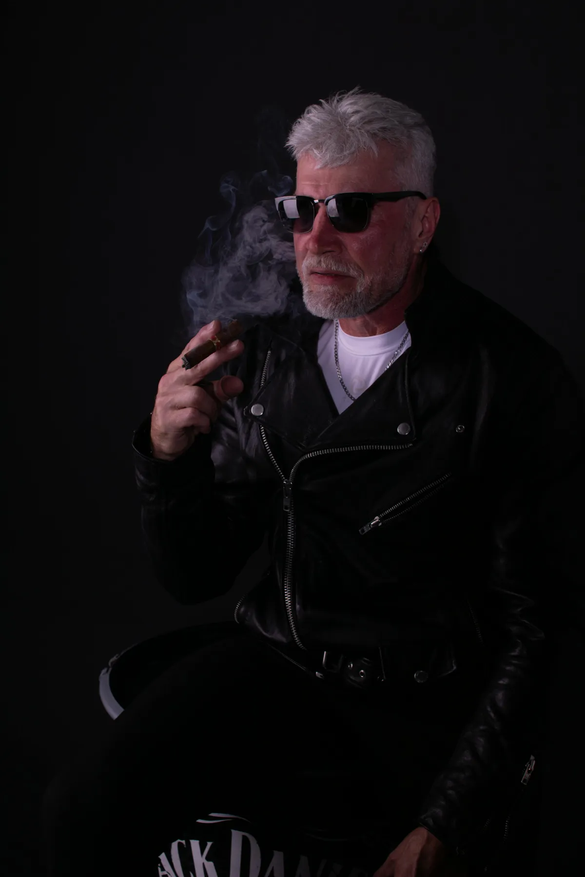 A man wearing a well-worn black leather biker jacket